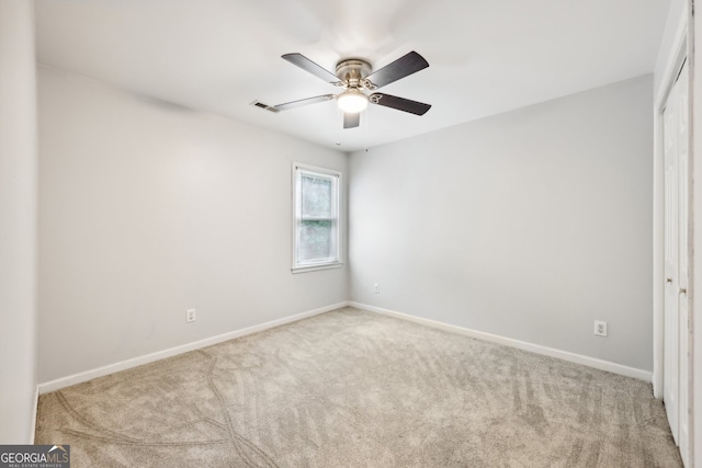 spare room featuring light colored carpet and ceiling fan