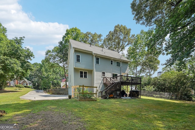 rear view of property featuring a wooden deck and a lawn