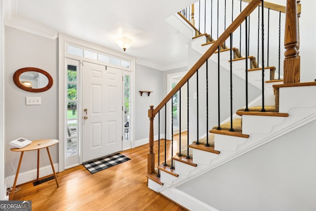 foyer entrance featuring crown molding and hardwood / wood-style floors