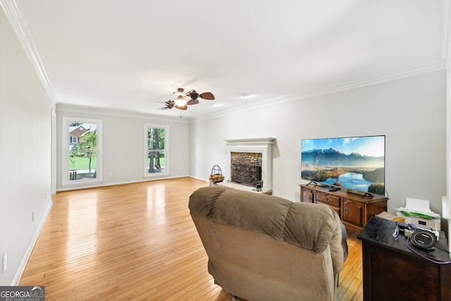 living room featuring light hardwood / wood-style floors, ornamental molding, and ceiling fan