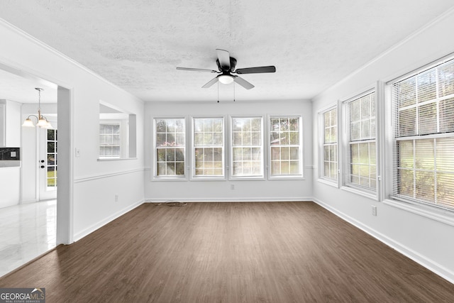 unfurnished sunroom featuring ceiling fan with notable chandelier