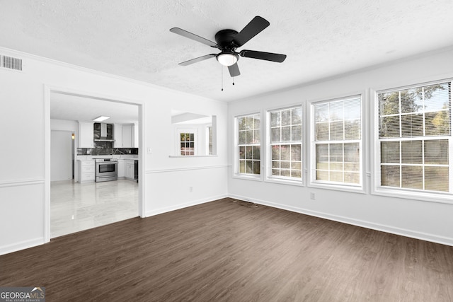 unfurnished living room with dark wood-type flooring, a textured ceiling, and ceiling fan