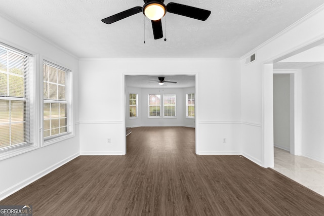 empty room with dark hardwood / wood-style floors, a textured ceiling, and a wealth of natural light