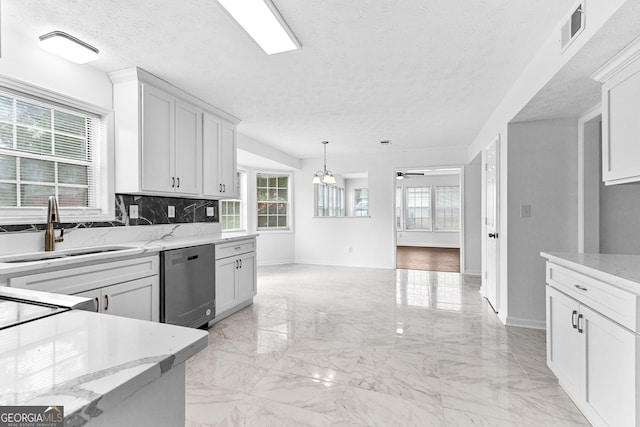 kitchen featuring sink, dishwasher, white cabinets, and a textured ceiling