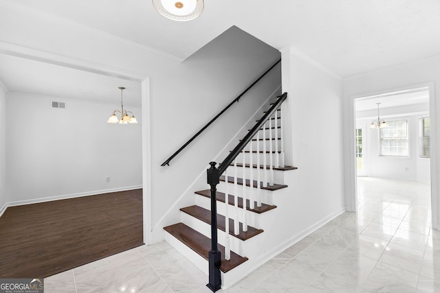 staircase featuring wood-type flooring, ornamental molding, and an inviting chandelier