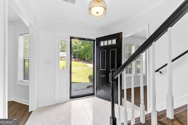 foyer entrance with light hardwood / wood-style flooring and crown molding