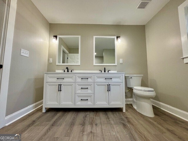 17843 Main St, Woodbury, GA 30293 - bathroom featuring vanity, toilet, and hardwood / wood-style floors