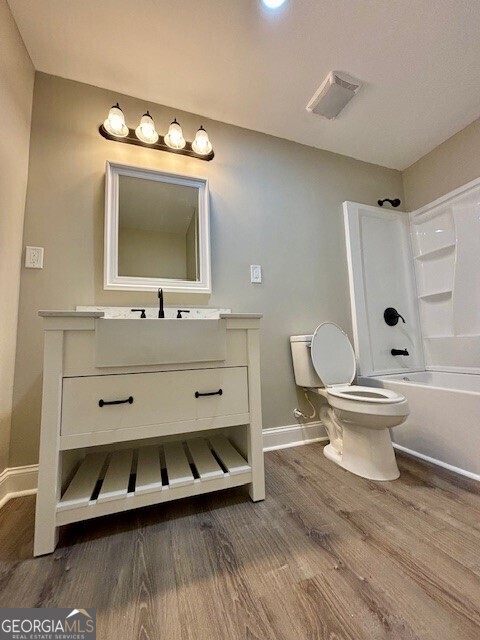 17843 Main St, Woodbury, GA 30293 - full bathroom featuring toilet, hardwood / wood-style flooring, vanity, and shower / bath combination