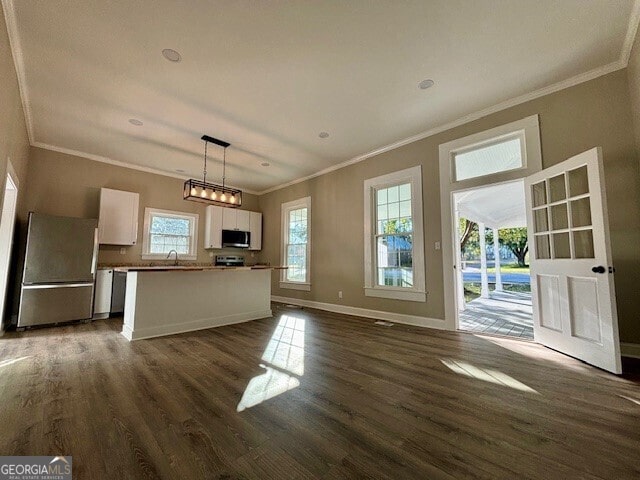 17843 Main St, Woodbury, GA 30293 - kitchen with dark hardwood / wood-style floors, stainless steel appliances, ornamental molding, pendant lighting, and white cabinets