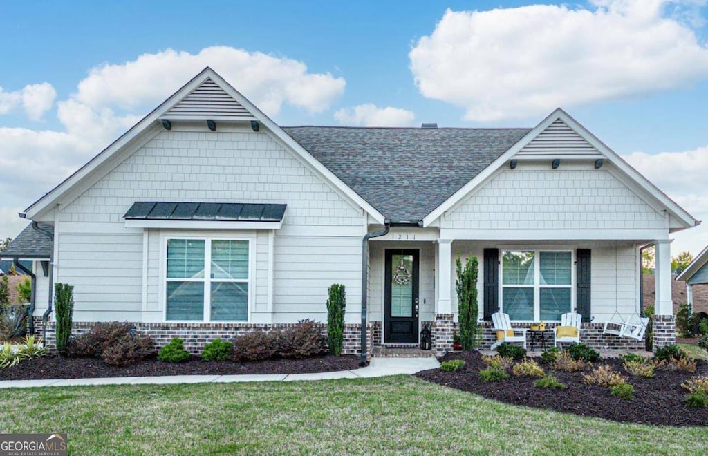 craftsman-style house featuring a porch and a front lawn