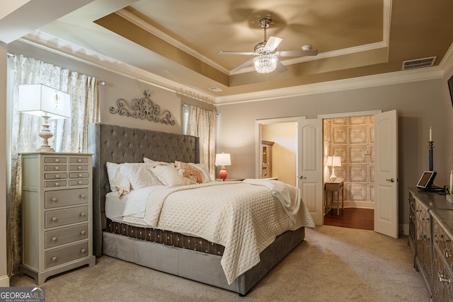 carpeted bedroom with crown molding, a tray ceiling, and ceiling fan