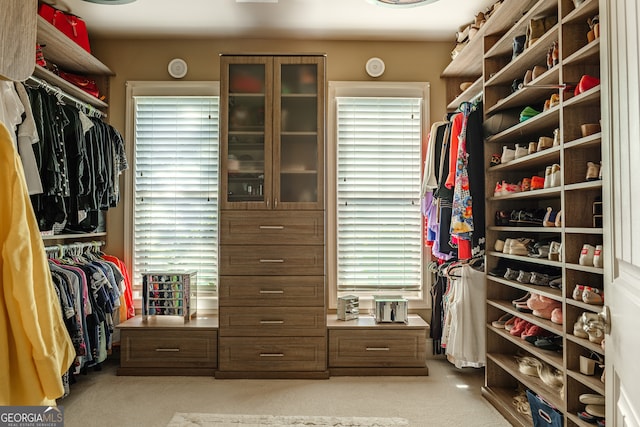 walk in closet featuring light colored carpet