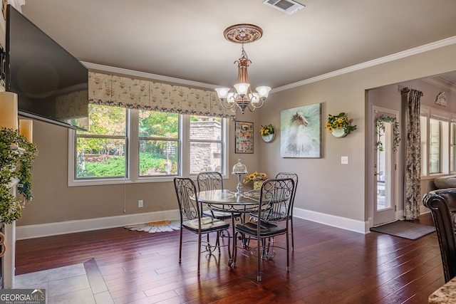 dining space with crown molding, a healthy amount of sunlight, and dark wood-type flooring