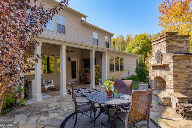 view of patio / terrace with ceiling fan and an outdoor stone fireplace