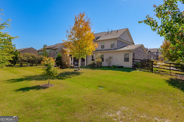 rear view of house featuring a yard