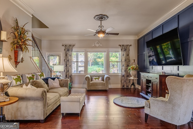 living room featuring ornamental molding, ceiling fan, a fireplace, and dark hardwood / wood-style flooring