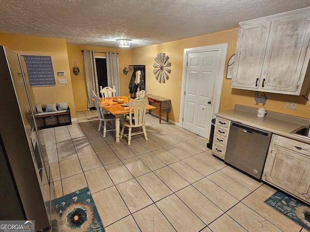 kitchen with light tile patterned flooring, a textured ceiling, and stainless steel appliances