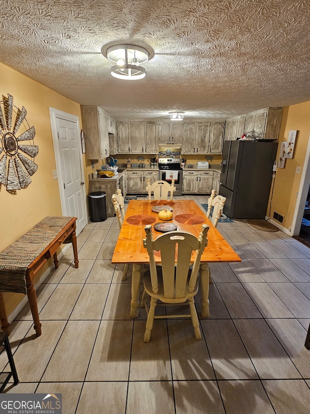 tiled dining area with a textured ceiling