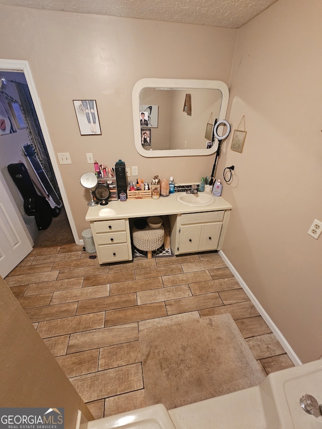 bathroom featuring vanity, hardwood / wood-style flooring, and a textured ceiling