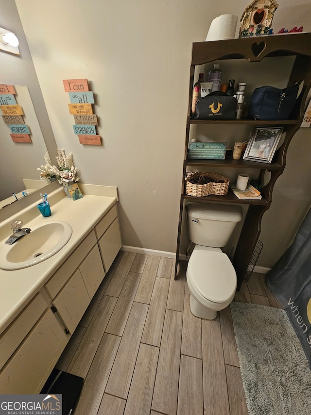 bathroom featuring vanity, hardwood / wood-style flooring, and toilet