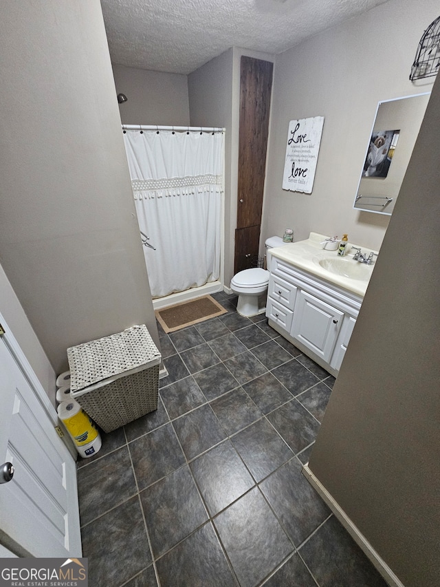 bathroom featuring tile patterned floors, toilet, vanity, a textured ceiling, and walk in shower