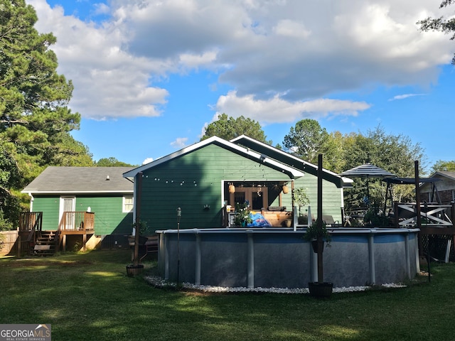 back of property featuring a swimming pool side deck and a lawn