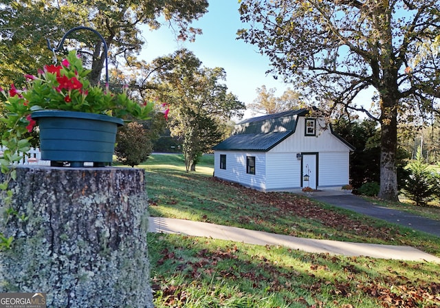 view of home's exterior featuring an outbuilding and a lawn