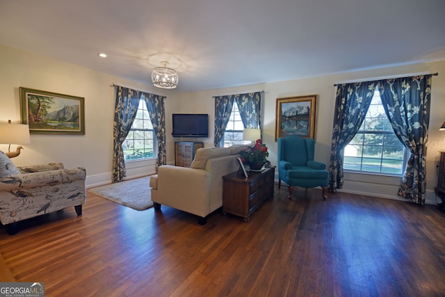 living room featuring a chandelier and dark wood-type flooring