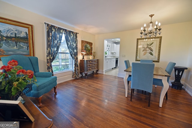 dining area with dark wood-type flooring and an inviting chandelier