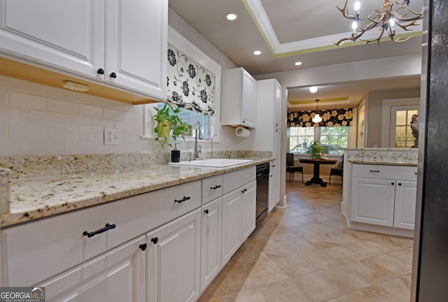 kitchen with ornamental molding, white cabinets, light stone countertops, and hanging light fixtures