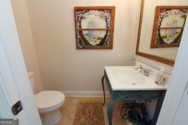 bathroom with toilet, vanity, and tile patterned flooring