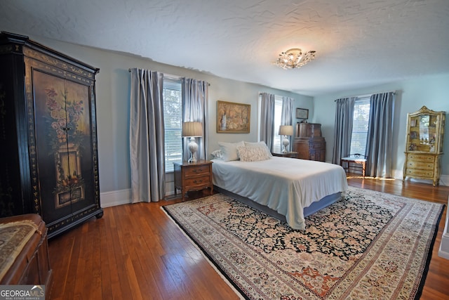 bedroom featuring dark wood-type flooring and a textured ceiling