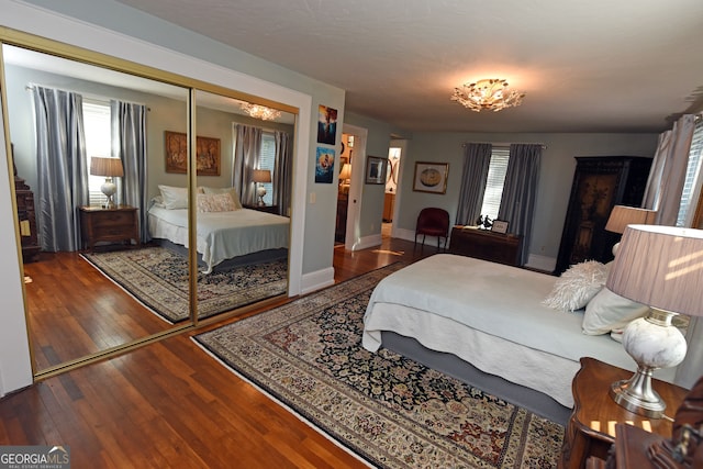 bedroom featuring a closet, multiple windows, and hardwood / wood-style floors