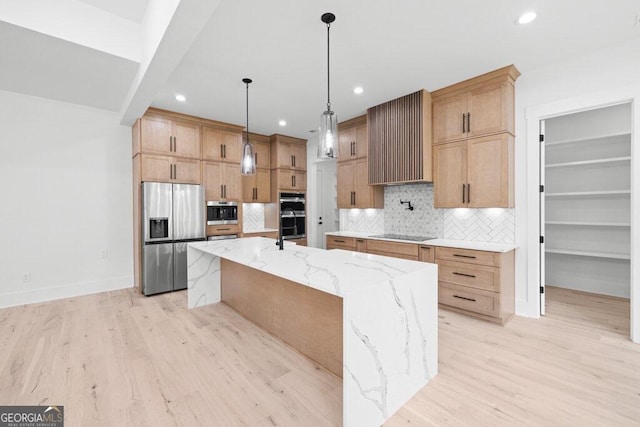 kitchen featuring a spacious island, stainless steel appliances, backsplash, and light hardwood / wood-style floors