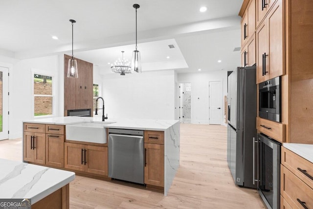 kitchen with an island with sink, stainless steel appliances, wine cooler, sink, and pendant lighting