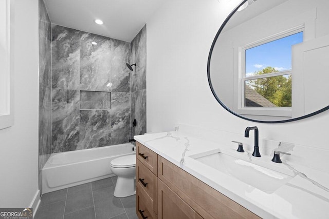 full bathroom featuring vanity, tiled shower / bath combo, toilet, and tile patterned flooring