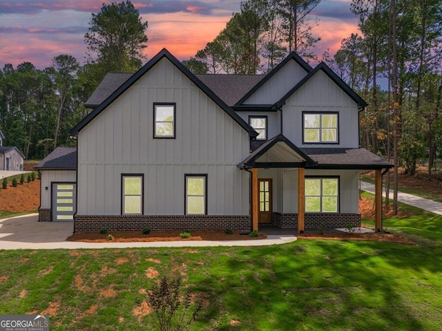 modern farmhouse with a yard, a garage, and a porch