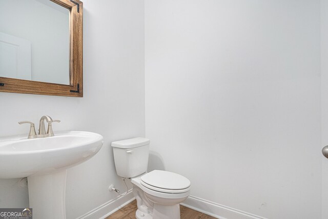 bathroom featuring toilet, hardwood / wood-style flooring, and sink