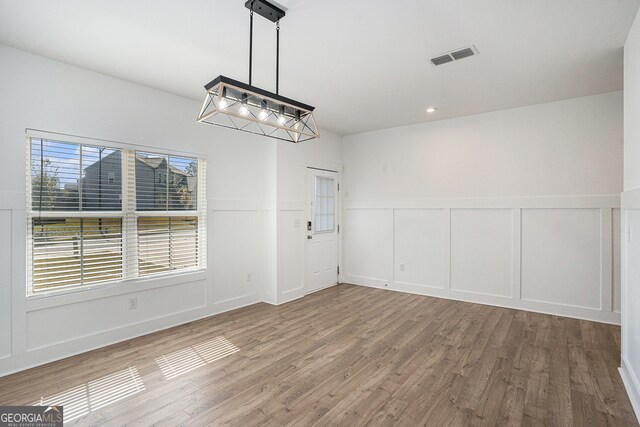 unfurnished dining area featuring wood-type flooring