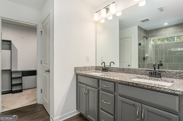 bathroom with vanity, a tile shower, and hardwood / wood-style floors