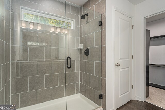 bathroom featuring a shower with door and wood-type flooring