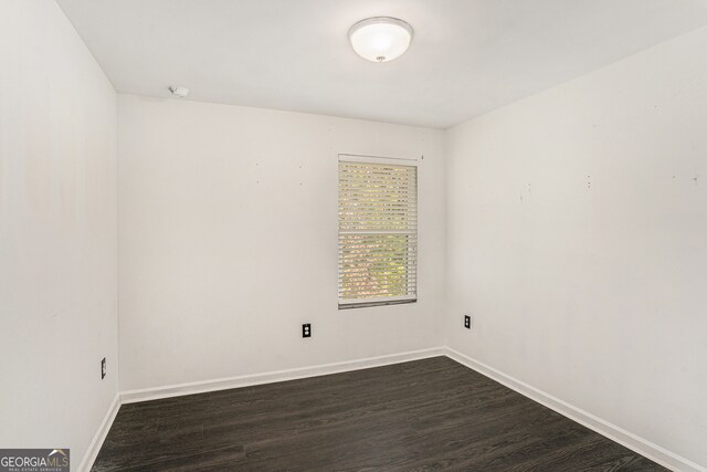 unfurnished room with dark wood-type flooring