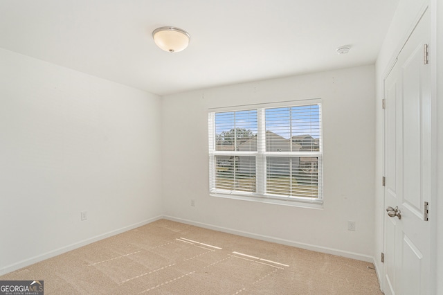 unfurnished room featuring light carpet