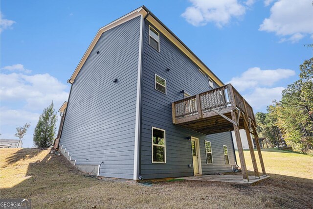 rear view of property featuring a yard and a wooden deck