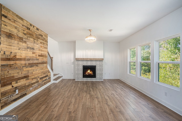 unfurnished living room featuring dark hardwood / wood-style floors and a tiled fireplace