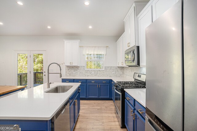 kitchen featuring a healthy amount of sunlight, sink, appliances with stainless steel finishes, and white cabinetry