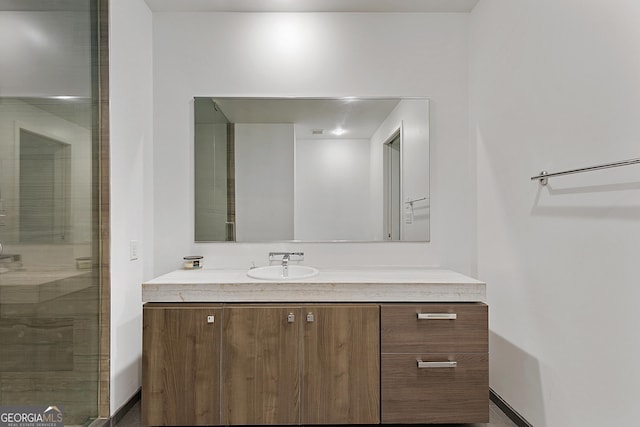 full bath featuring a stall shower, vanity, and baseboards