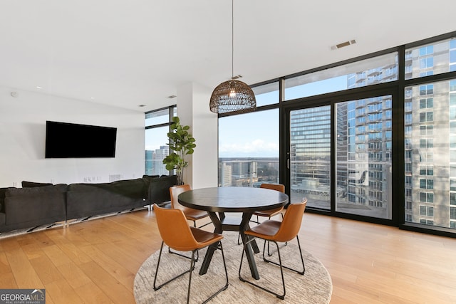 dining room with light hardwood / wood-style floors and expansive windows