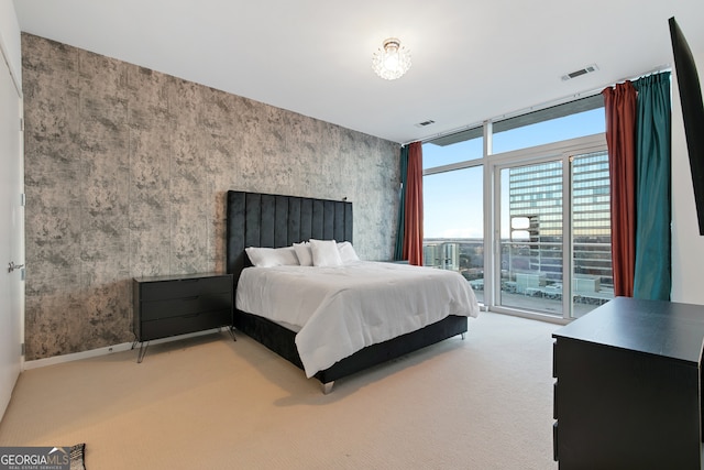 bedroom featuring floor to ceiling windows, visible vents, access to exterior, and carpet flooring