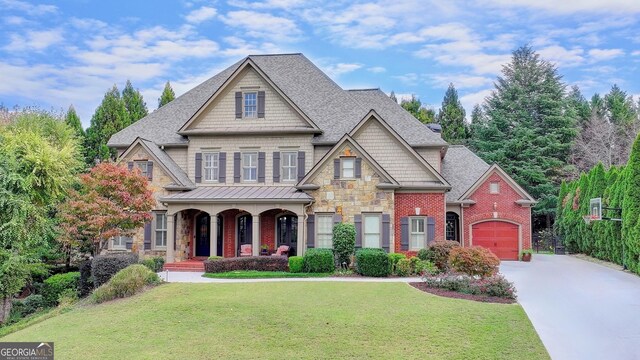 craftsman-style house featuring a front lawn, covered porch, and a garage